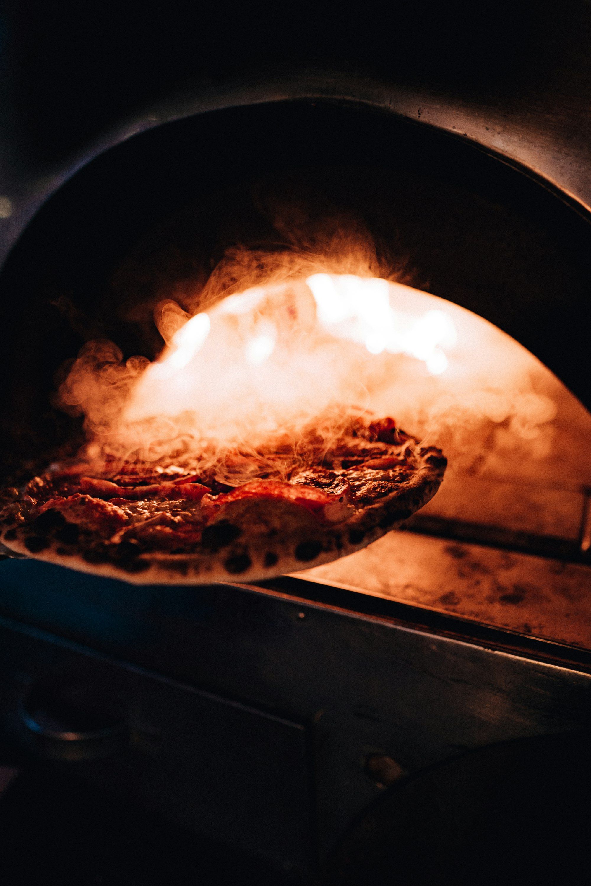 Pizza backt im glühenden Steinofen